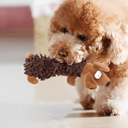 petit chien brun avec son jouet pour chiot dans la bouche