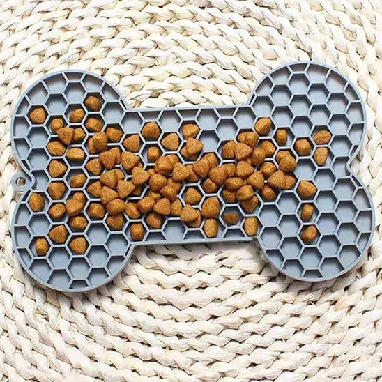 Tapis de léchage chien gris en forme d’os avec croquettes réparties dans les alvéoles
